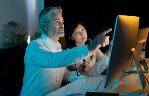 Legal professionals reviewing documents and information on a computer for process service.
